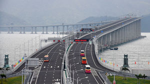 Buses drive along the bridge on its first day of operation