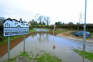 A car just makes it through flood water in Gilbert Lane, Wombourne, with many drivers choosing to turn around instead