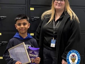 Ayaan, 8, pictured with his award and chocolates alongside call handler Rebecca