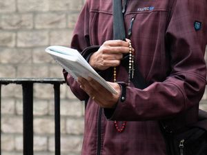 A close-up of a prayer book and rosary beads