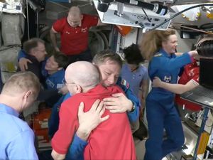 Astronauts hugging and smiling on the ISS