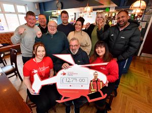 Steve Flavell (centre) with Candice and Kay Starkey from Air Ambulance, and people from local businesses who raised money for the charity. They are pictured at The Old Bush Inn, Bradley Lane, Bilston.