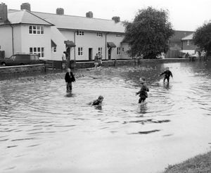 'Youngsters play in the floods in Guy Avenue, Wolverhampton, after a thunderstorm on August 14, 1984.' 