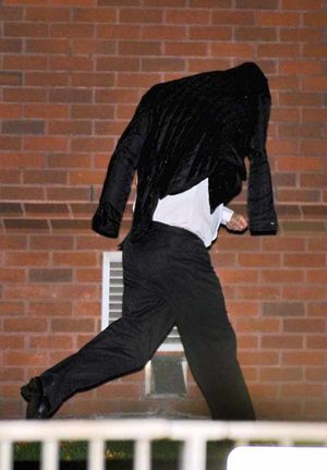 Neil Harper covers his face at court