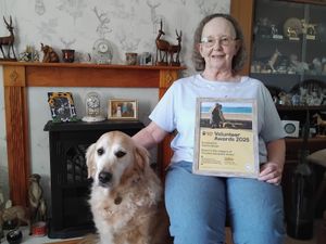 Sandra Boden holding her award and sitting next to retired guide dog mum Millie. Picture: Guide Dogs