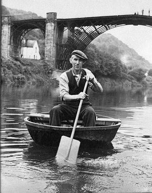 Ironbridge coracle maker Eustace Rogers, with the Iron Bridge in the background in around the 1960s