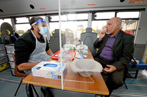 Mohammed Arif, interim-chair of UMO takes the test in the mini bus test centre whilst watched on by Amjad Ali