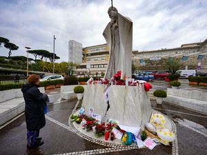 A woman prays for Pope Francis in front of the Agostino Gemelli Polyclinic, in Rome