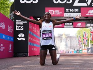 Tigst Assefa celebrates winning the women’s elite race during the TCS London Marathon.