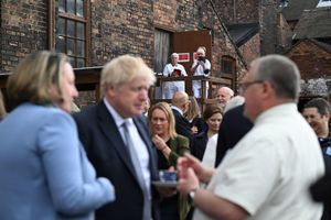 People take photos of International Trade Secretary Anne-Marie Trevelyan (left) and Prime Minister Boris Johnson talking to local business people after a regional cabinet meeting at Middleport Pottery in Stoke on Trent. Photo: Oli Scarff/PA Wire