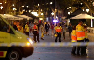 Emergency workers stand on a blocked street in Barcelona in the wake of the terrorist attack