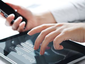 Female hands work with online banking on touch screen device