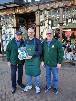 Mark Carter of Tanners handing a hamper to Lion Ken Duffield and Lion John Boydell