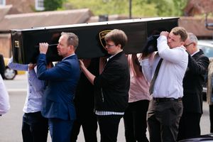 Loved ones of Toby Jones carry his coffin into church