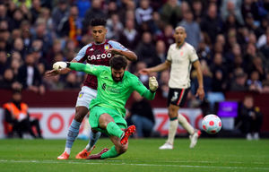 Liverpool goalkeeper Alisson kicks the ball clear under pressure