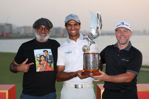 Aaron Raiwith his father Amrik and caddie Jason Timmis alongside the trophy on the 18th green at the Abu Dhabi HSBC Championship (Photo by Richard Heathcote/Getty Images)