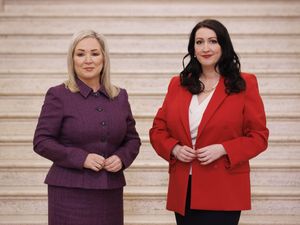 Michelle O'Neill and Emma Little-Pengelly smiling at the bottom of a marble staircase