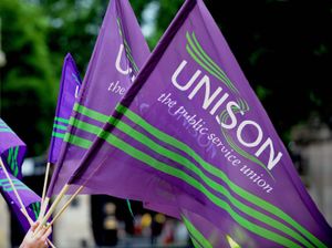 Purple and green Unison flags being waved