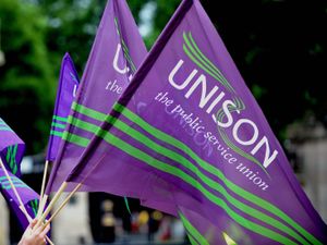 Purple and green Unison flags being waved