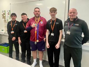Kevin Fenner shows off the gold and silver medals he won with the Lionesses at the Euros and World Cup to students Ryan Povey, Liam Downing, Ethan Wynn, and sports lecturer Jason Jones