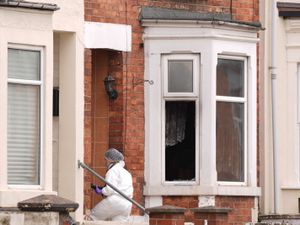 A forensics officer enters the property in Newcomen Road, Wellingborough