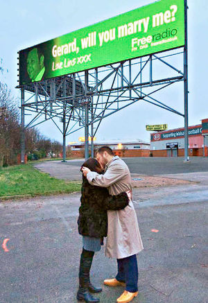 Gerard's acceptance is celebrated with a kiss underneath the sign organised by Lindsay