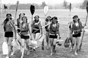 The caption of this June 1975 print reads: 'Equipped with paddles and lifejackets, girls from Ounsdale Comprehensive School, Wombourne, and Gnosall Comprehensive School, near Stafford, on their way to the River Treant at Great Haywood for canoe tuition. They are on a week's canoeing and camping course at Staffordshire schools' outdoor education centre at Shugborough.' 