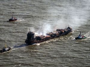 Tug boats shadow the Solong container ship