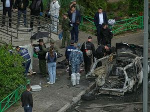 Investigators work at the scene of the car bomb in Moscow