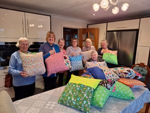 Supporting image for story: Craft group donates handmade reading pillows to local children