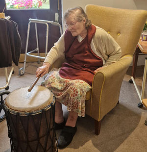 Resident at HC-One’s Perry Locks Care Home playing the African drums