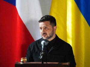 Volodymyr Zelensky speaking from a lectern