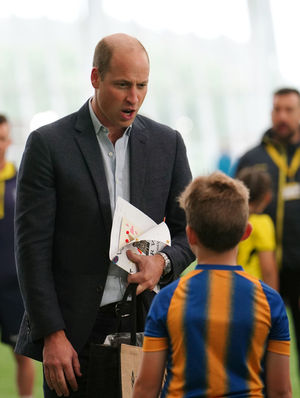 The Prince of Wales talks to youngsters in Shrewsbury Town shirts during his visit to St George's Park