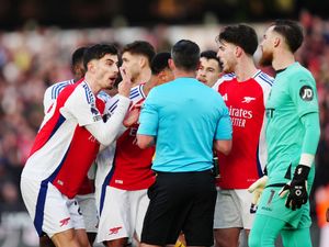 Arsenal players confront referee Michael Oliver after showing Myles Lewis-Skelly a red card during the Premier League match at Molineux