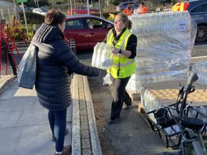 A resident collects water at a bottle station at Asda, Totton, on Thursday