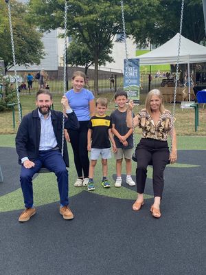 Councillor David Williams and Councillor Lisa Wilson have a go on the new swings with Sophie, Jacob and Oscar