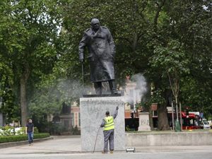 A worker cleans graffiti from the plinth of the statue of Sir Winston Churchill at Parliament Square