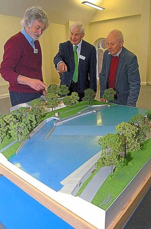 From left, Dave Green, Mark Scutt, and Len Marlow look at a model depicting the weir in Shrewsbury,
