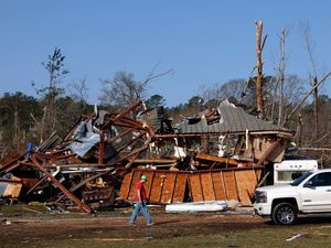 Residents look for personal belongings in the damage following a tornado