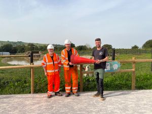 Highways crew members, Wayne Bridgett and Paul Williams, donating the traffic cones to James Butler at Peak Wildlife Park.