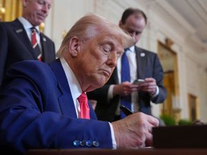 President Donald Trump signs an executive order during an event in the East Room of the White House, Tuesday, April 8, 2025, in Washington