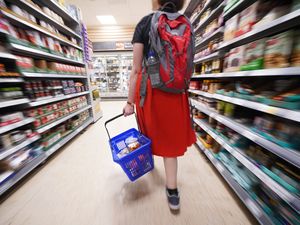 A shopper walking through the aisle of a supermarket