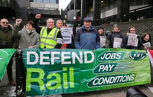 Mick Lynch, general secretary of the Rail, Maritime and Transport union (RMT), center, joins the members of rail workers during a strike outside Euston station in London, Tuesday, Dec. 13, 2022. (AP Photo/Kin Cheung).
