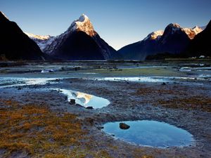 Mitre Peak reflected in the puddles left from the low tide at Milford Sound