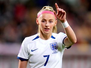 Chloe Kelly, wearing an England shirt, points to the stands