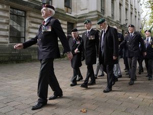 Veterans march down a street