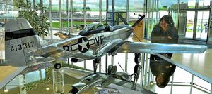 Visitor services assistant Janet Ward looks at a scale model of a P51-D Mustang in the reception at RAF Cosford