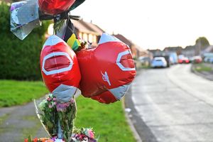 Arsenal balloons and Jamaican flags adorn lampposts near the house where the tragic stabbing occurred