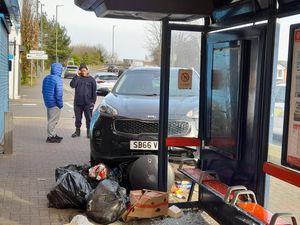The car came to rest next to a bus shelter