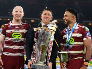 Liam Farrell (left) head coach Matt Peet (centre, holding trophy) and Bevan French celebrate after the Grand Final in October 2024